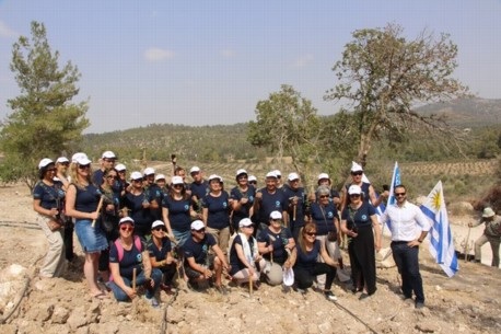 הכומר חורחה מארקס וחברי קהילתו בטקס הנטיעה.  צילום: ארכיון הצילומים של קק"ל