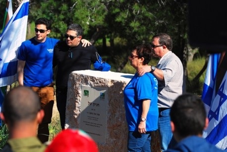הוריו ואחיו של טל נחמן ז"ל ליד אבן ההקדשה לזכרו. צילום: דניס צין